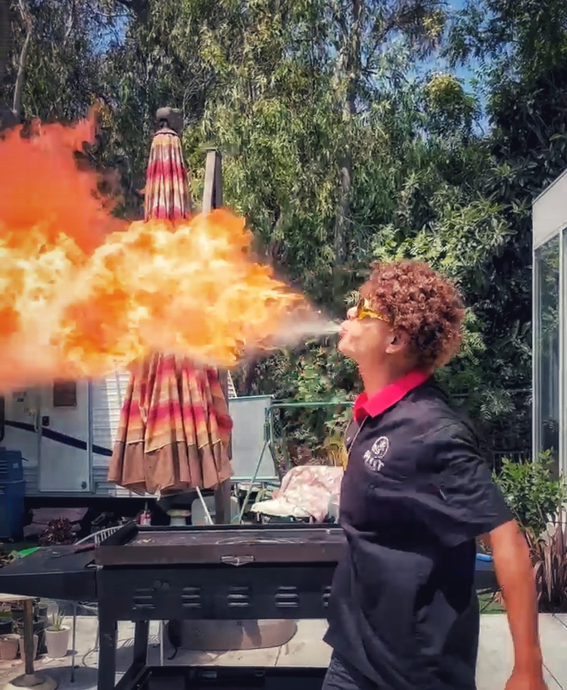 Hibachi chef breathing fire at a backyard party