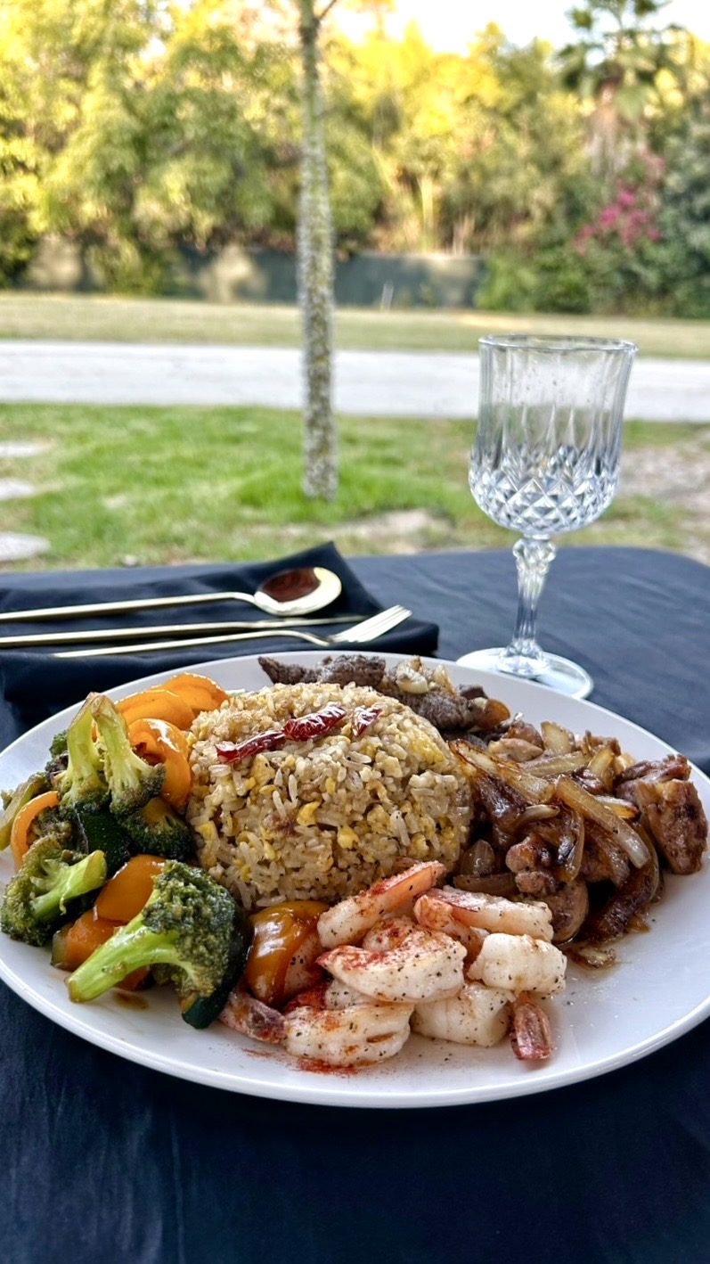 A plated hibachi dinner served outdoors at a backyard table